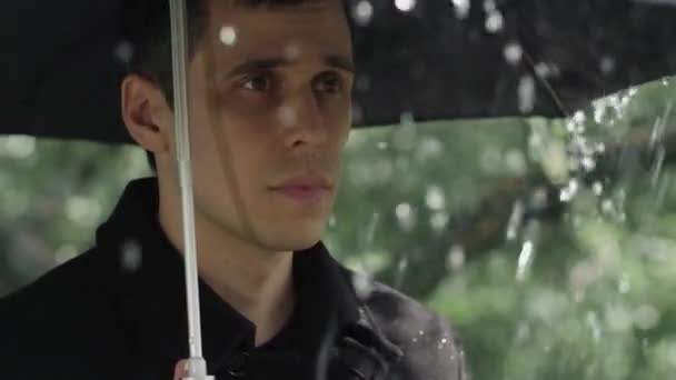 Egy férfi esernyő alatt a temetésen. — Stock videók