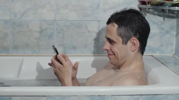 Homem na banheira com telefone celular — Vídeo de Stock