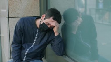 Yüz maskesinde koronavirüs belirtileri olan genç bir adam.