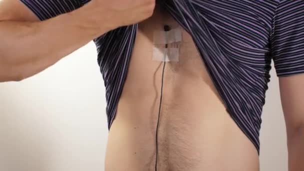 Uomo che mostra il microfono sotto la t-shirt — Video Stock