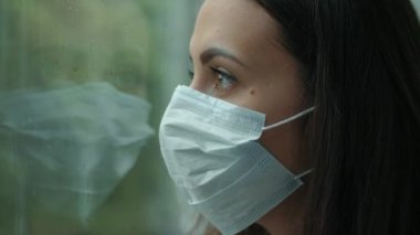 Pencerenin arkasındaki maskeli kadın.