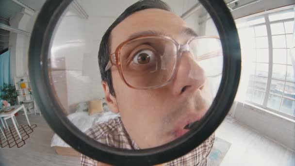 Nerd looks through magnifier — Stock Video