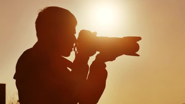 Fotograf robiący zdjęcia o zachodzie słońca — Wideo stockowe