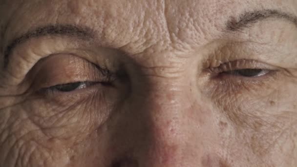 Глаза пожилой женщины смотрят в камеру — стоковое видео