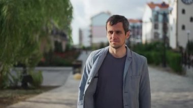 A man experiences a sudden coughing fit while walking in an urban environment