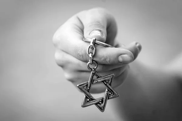 Young woman\'s hand holding a Star of David, \
