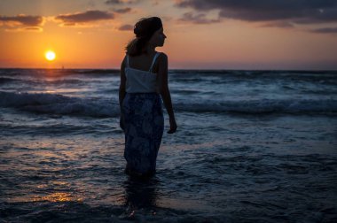 Günbatımında Akdeniz üzerinden uzun elbiseli güzel bir beyaz kız. Yalnızlık kavramı, kendini arıyorsun.