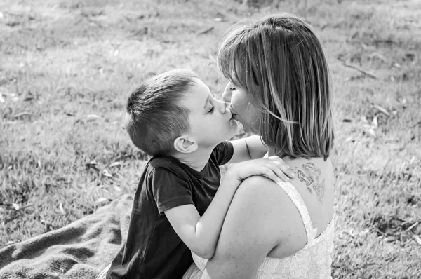 Sevimli küçük beyaz çocuk annesi öpüşme. Anne ve oğlu kavramı görüntü seviyorum. Siyah beyaz resim.