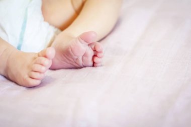 Küçücük ayakları yumuşak pembe bir arka plan bir yeni doğmuş bebek kız. Bir haftalık bebek bebek. İlk gün onu hayat görüntü.