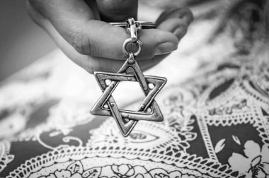 Bir davut yıldızı - Magen David Anahtarlık tutan genç kadının el. İsrail devleti, Holokost Anma, Yahudilik, Siyonizm kavramı görüntü. Siyah beyaz resim.
