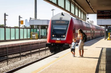Holon, İsrail. 27 Eylül 2018. Anne ve çocuk için gelen tren bekleyen platformu. Kırmızı Çift Kişilik güverte Bombardier koç. Tehlike, risk, çok platform kenarına yakın.