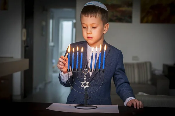 Симпатичный Кавказский Еврейский Мальчик Зажигает Свечи Традиционной Хануке Меноре Канделябр — стоковое фото