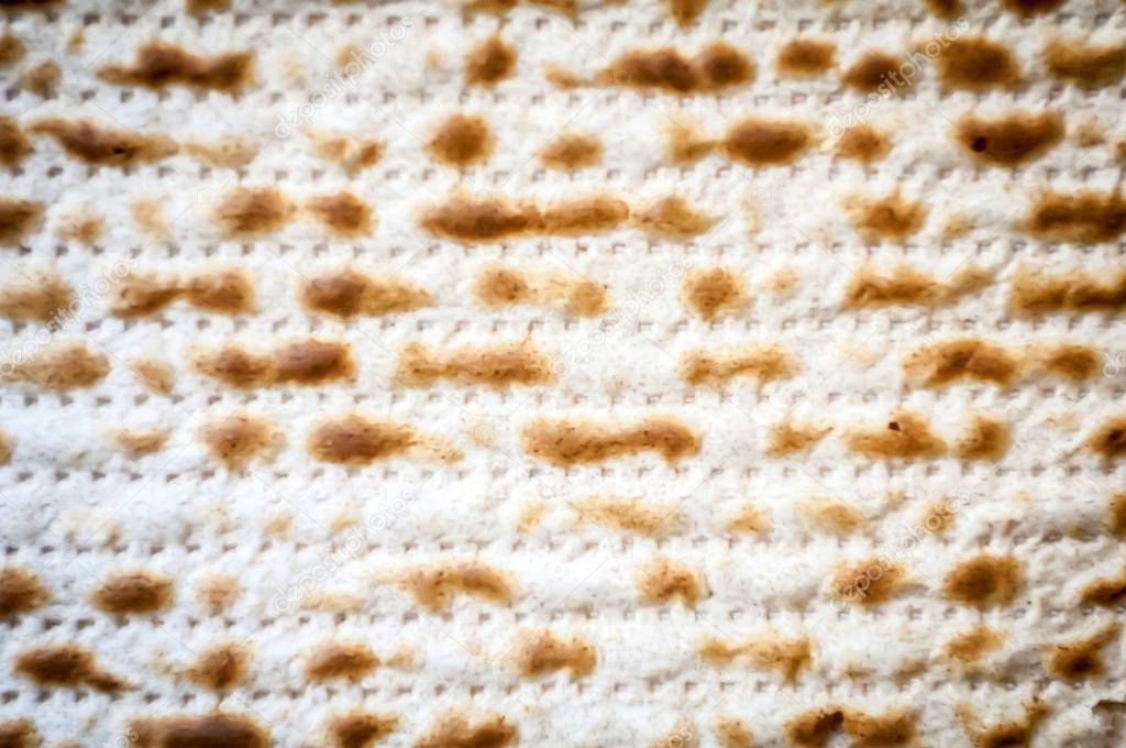 Jewish traditional Matso unleavened bread textured background, matso bread is made during the Jewish Passover Pesach holiday. Pesach concept greeting card.