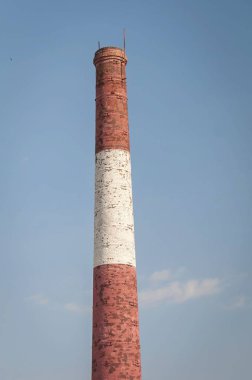 Kırmızı ve beyaz eski tuğla Endüstriyel boru mavi gökyüzü. Eski Sanayi kavramı görüntü. Eski fabrika yardımla, ekoloji, endüstriyel yenileme, küreselleşme.