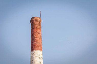Kırmızı ve beyaz eski tuğla Endüstriyel boru mavi gökyüzü. Eski Sanayi kavramı görüntü. Eski fabrika yardımla, ekoloji, endüstriyel yenileme, küreselleşme.