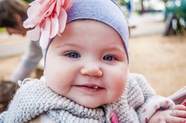 Komik, sevimli ve şirin altı ya da yedi aylık bebek kız mavi gözlü dudaklarında bir yerde dışında kurabiye kırıntısı ile yemek. Portre beyaz bebek yakın. İlk tat. Bahar ya da sonbahar