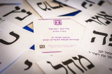 Holon, Israil. 9 Nisan 2019. Israil parlamento seçimlerinde Knesset 'e katılmak için Ibranice 'de bir davetiye. Arka planda Ballot kağıtları. İsrail seçimleri yirmi ilk Knesset 2019.