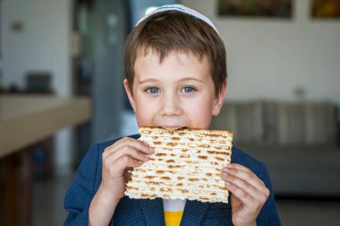 Elinde tutan ve geleneksel bir Yahudi matzo mayasız ekmek bir ısırık alarak sevimli Kafkas Yahudi çocuk. Yahudi Passover Pesach kavramı görüntü.