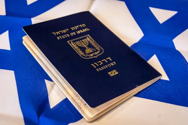 A blue passport of the State of Israel on Israeli flag on the background. Israel citizenship concept, Israeli biometric 