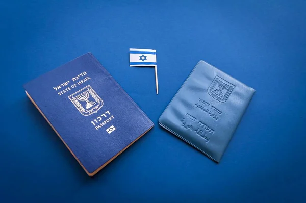 Israeli official documents: passport of Israel and national ID document on a dark blue background with a small flag of Israel. Israel citizenship concept