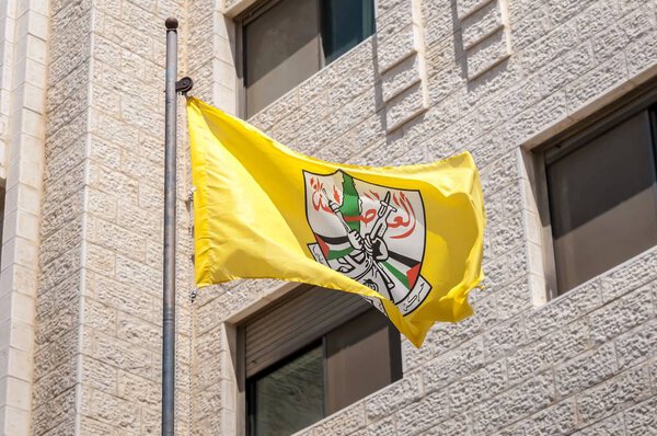 RAMALLAH, PALESTINE. August 31, 2019. The Fatah Palestinian political party flag waving by the party compound the downtown Ramallah, the de facto capital of Palestinian Authority.
