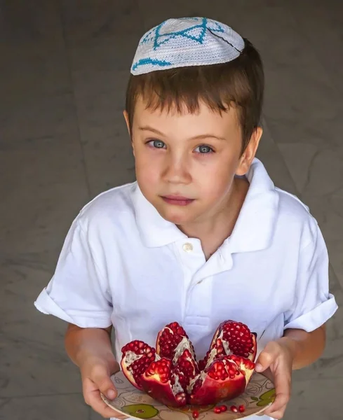 可爱的可爱的犹太考卡西亚男孩 头上拿着一盘分裂的石榴水果 罗什哈哈概念图片 — 图库照片