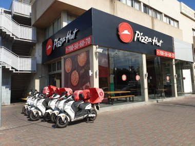 Sakin ol, israil. 11 Ağustos 2020. Koronavirüs salgınından dolayı kapalı bir Pizza Hut restoranı. Teslimat bisikletleri dışarıda zincirli. İsrail 'de iş kayıpları, ekonomik kriz.