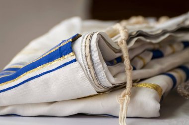 Tzitzit düğümlü katlanmış Tallit. Geleneksel bir Yahudi dua şalı. Dindar Yahudiler tarafından dini ayin sırasında giyilen püsküllü bir elbise.. 