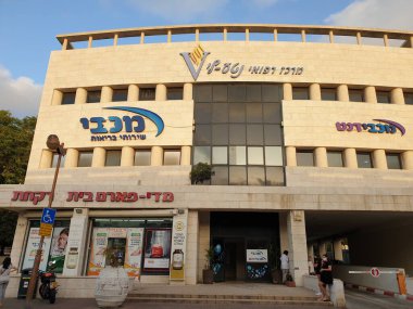 Sakin ol, israil. 30 Eylül 2020. Holon 'daki Maccabi Sağlık Hizmetleri Sağlık Merkezi dış görünüş, Maccabi logo resmi.