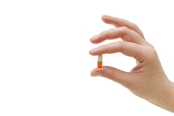 Una chica sosteniendo una cápsula naranja. Aislado sobre fondo blanco — Foto de Stock