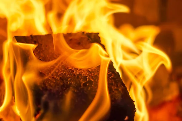 Burning fire with charcoal, firewood and fuel briquette in a fireplace in a country house. — Stock Photo, Image