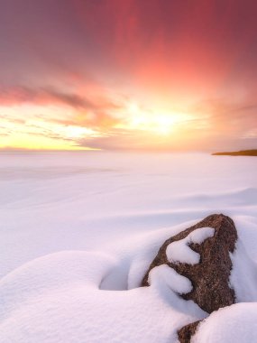 Kış günbatımı taşlarla karla kaplı. Doğanın kompozisyon.