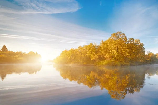 Symmetry reflection on the autumn river. Sunrise