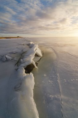 Soğuk kış akşam günbatımı gökyüzü bulutlar ışık denizde donmuş kenarı kırık oluşumu kar ve buz.