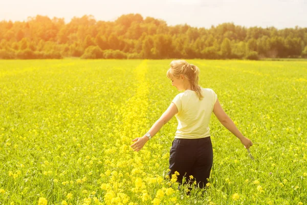 Happy Young Woman Enjoying Summer And Nature In Yellow Flower Field With Sunlight, Harmony And Healthy Lifestyle. Field Of Yellow Cowslip Flowers Or Primula Veris With Young Woman.