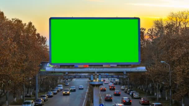 Un cartel con la llave verde del croma en el fondo de coches que se mueven rápidamente al atardecer — Vídeos de Stock