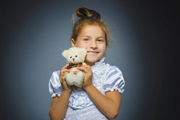 Ritratto di ragazza felice che gioca con orsacchiotto isolato su grigio — Foto Stock