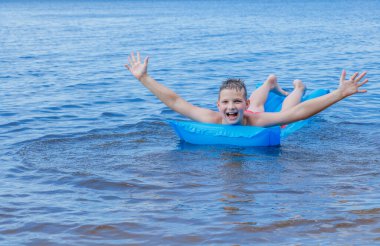 Denizdeki bebek yazın şişme yatakta yüzer..