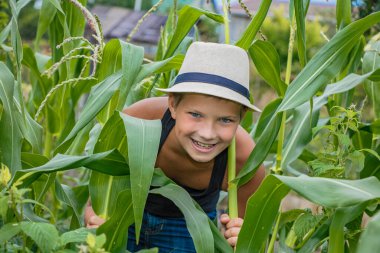 Doğada çocuk şapkası takan yaz çocuğu köyde mutludur.