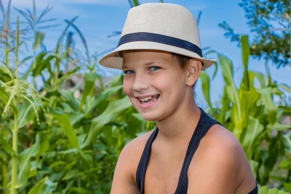 Estate ragazzo in un bambino cappello in natura felice sulla natura nel villaggio — Foto Stock