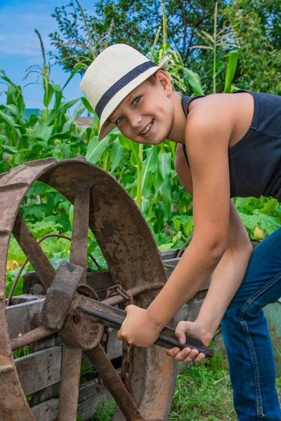 Verano niño en un sombrero de niño en la naturaleza feliz en la naturaleza en el pueblo —  Fotos de Stock