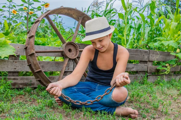 Verano niño en un sombrero de niño en la naturaleza feliz en la naturaleza en el pueblo —  Fotos de Stock