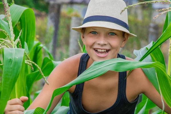 Verano niño en un sombrero de niño en la naturaleza feliz en la naturaleza en el pueblo — Foto de Stock