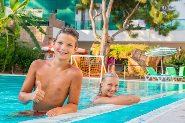 In summer, happy children bathe in the pool on vacation — Stock Photo, Image