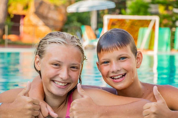 In summer, happy children bathe in the pool on vacation — Stock Photo, Image