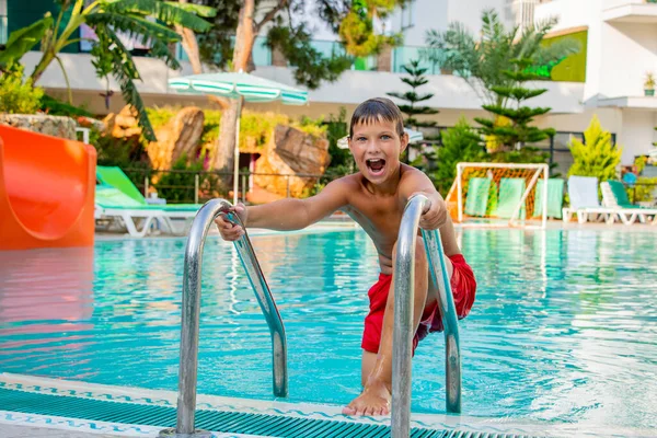 Young boy summer happy and contented in the pool in the summer — Stock Photo, Image