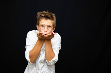 Güzel maskeli beyaz tişörtlü bir çocuk. Duygusal bir sevinç ve üzüntü içinde.