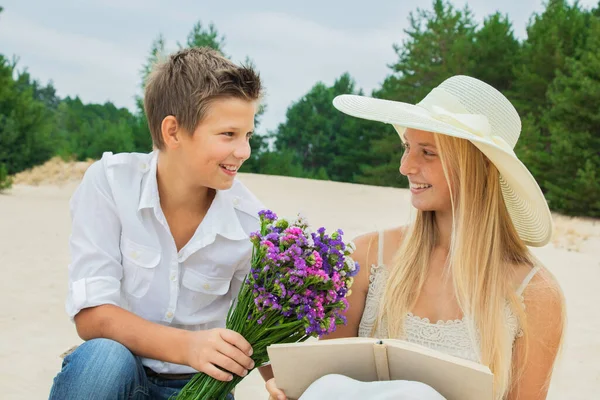 Ragazzo e ragazza con un bouquet di bel colore in natura in autunno ed estate su un appuntamento — Foto Stock