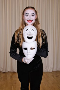 Odak noktası elinde maske olan gülümseyen pandomimci sanatçı. Yakın plan portre.