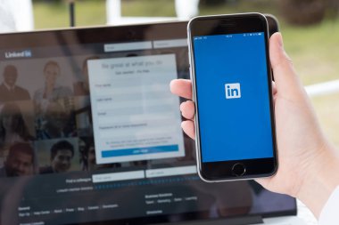Chiang Mai, Tayland Jan 07 2018: sosyal ile bir iphone 6s tutan işadamı ağ hizmeti LinkedIn üstünde belgili tanımlık perde. iPhone 6s oluşturuldu ve Apple Inc tarafından geliştirildi.